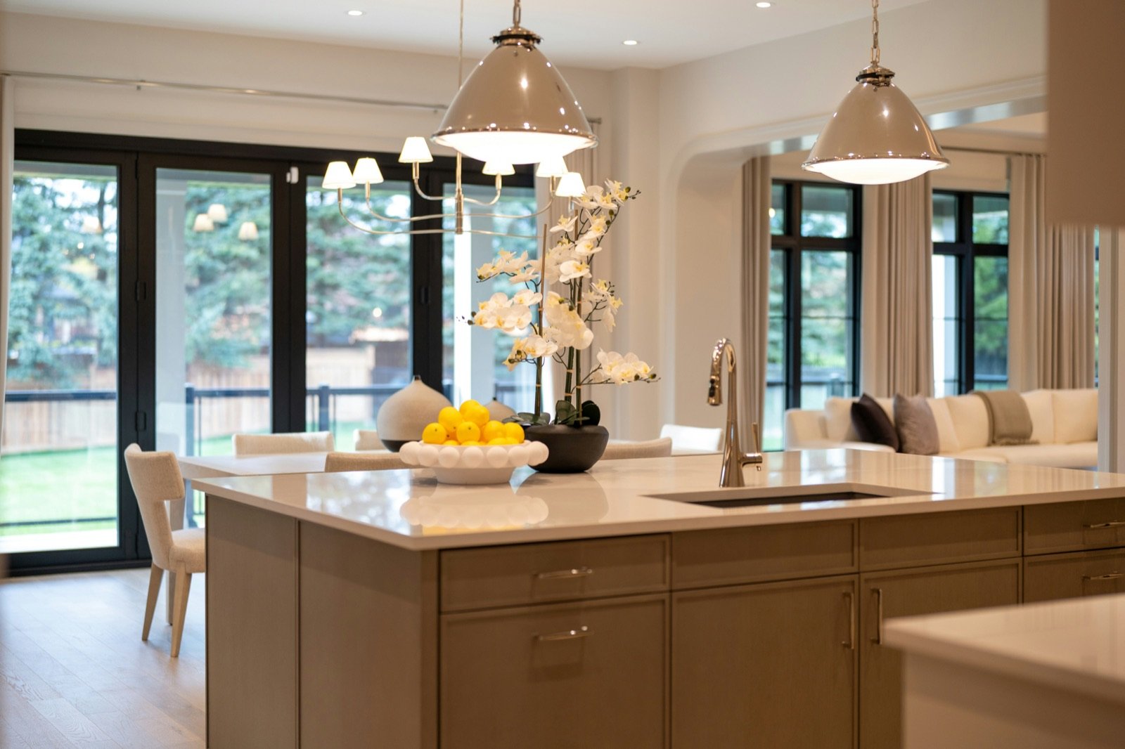 Three glass pendant lights hanging in a row above a white kitchen island